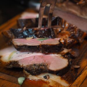 Close-up of juicy grilled steak slices seasoned on a wooden cutting board, perfect for culinary presentations.