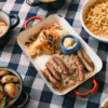Delicious Bavarian sausages and sides served elegantly on a checkered tablecloth.