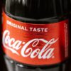 Set of glass bottles of refreshing cold coke with red sticker placed close to each other