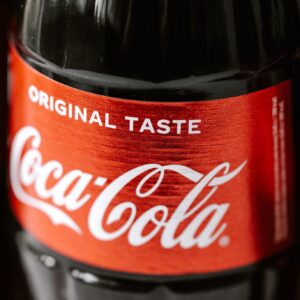 Set of glass bottles of refreshing cold coke with red sticker placed close to each other